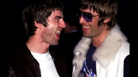 PA Media Noel and Liam Gallagher pictured laughing together in 2001