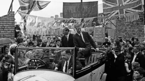 Staff/Mirrorpix via Getty Images A black and white image of the Charlton brothers returning to Ashington after the World Cup