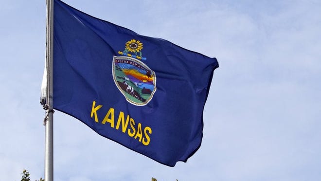 The Kansas state flag flying on a flagpole.