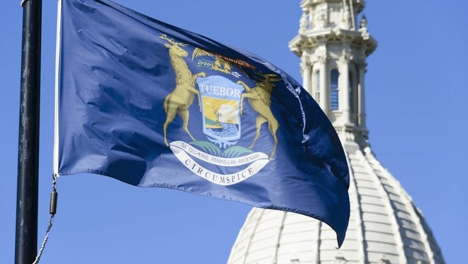 The Michigan state flag fluttering in front of a domed building.