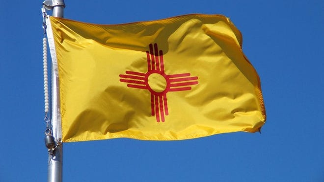 The New Mexico state flag in front of a blue sky.