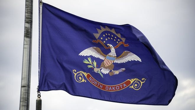 The North Dakota state flag flying on a flagpole.