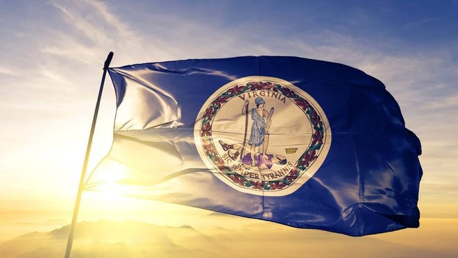 The Virginia state flag flying in front of a sunny sky.