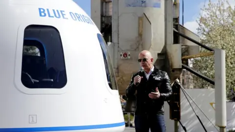 Reuters Jeff Bezos addresses the media next to the New Shepard launch vehicle
