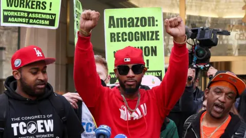 Reuters Amazon Labour Union (ALU) organiser Christian Smalls reacts as ALU members celebrate official victory after hearing results regarding the vote to unionize, outside the NLRB offices in Brooklyn, New York City, U.S., April 1, 2022.