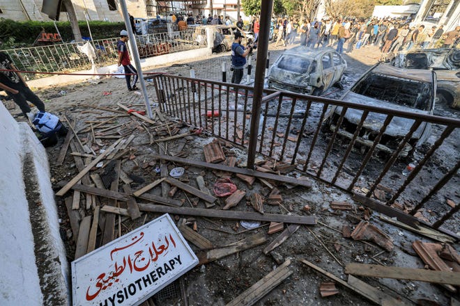 People search through debris outside the site of the Ahli Arab hospital in central Gaza on Oct. 18, 2023 in the aftermath of an overnight blast there. A blast ripped through a hospital in war-torn Gaza killing hundreds of people late on October 17, sparking global condemnation and angry protests around the Muslim world.