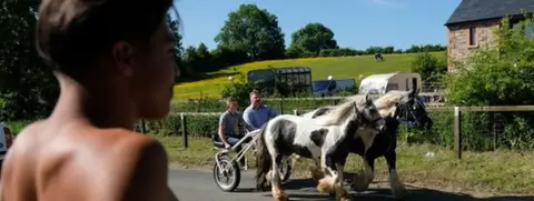 PA A young man stands and watches the horses on the first day of the Appleby Horse Fair