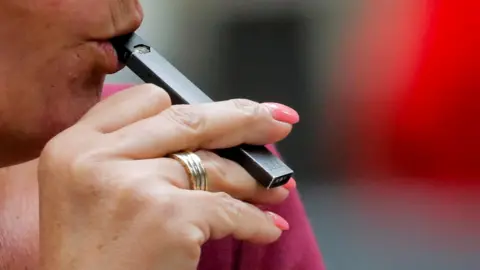 Reuters A woman vapes a Juul