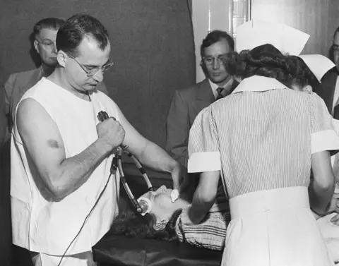 Getty Images Freeman's colleague Dr James Shanklin uses electrical apparatus to prepare a patient for transorbital lobotomy