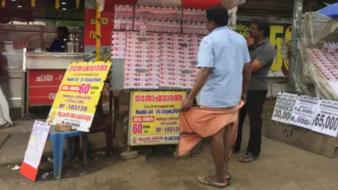 Getty Images Man selling lottery tickets in the city of Thiruvananthapuram (Trivandrum), Kerala, India.