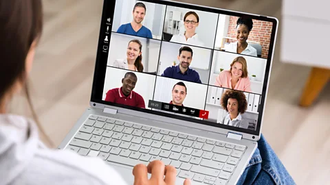 File image of a worker looking at faces of several colleagues on screen