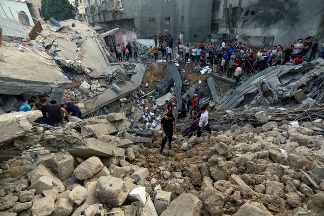 Palestinians inspect the site where there was a Greek Orthodox church, destroyed following Israeli airstrikes on Gaza City, Friday, Oct. 20, 2023.