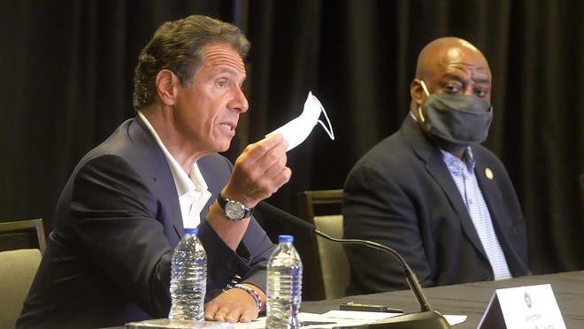 New York Gov. Andrew Cuomo waves a mask to make a point during a news conference in Savannah, Ga., with Savannah Mayor Van Johnson.