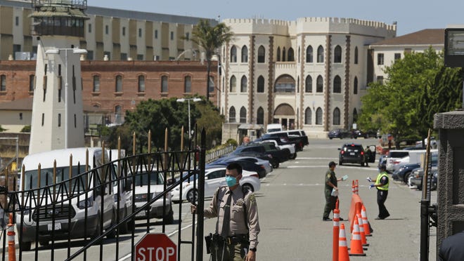 A correctional officer closes the main gate at San Quentin State Prison in California, where a second inmate on death row died from what appears to be complications of the novel coronavirus amid an outbreak sweeping through the prison.