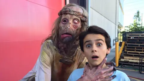 Javier Botet Javier fake-choking one of the children on set of It while in leper costume