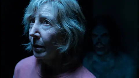 Sony A monster character lurks in the background of a shot