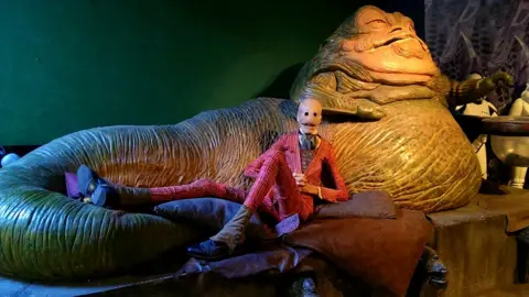 Javier Botet Javier lying down, in costume, next to Jaba The Hut