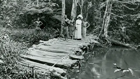 Anti-Slavery International English missionary and photographer Alice Seeley Harris crossing a bridge in the Belgian Congo, c1900