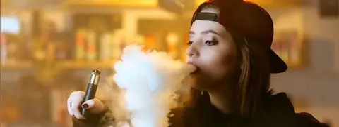 Getty Images A woman smokes an e-cigarette