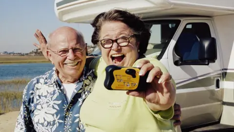 Getty Images Couple holding a disposable camera