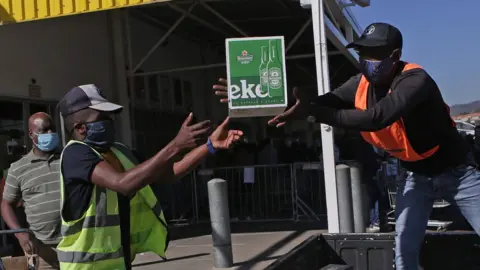 AFP Workers help a customer load alcohol in his van moments after purchasing at Makro Silverlakes Liquor Store in Pretoria on June 1, 2020