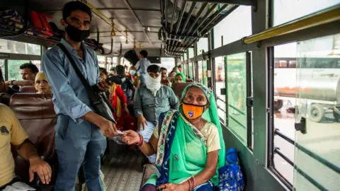 Getty Images A bus conductor issues tickets to a female passenger in Uttar Pradesh.