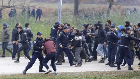 Getty Images Migrants are stopped by the Bosnian police 200 metres from the border