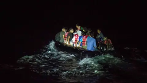 Getty Images A rubber dinghy full of migrants crossing to the Greek island of Lesbos at night