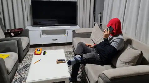 Elham Noor 'Elham Noor' sits in a living room