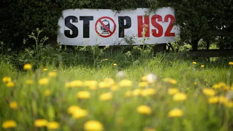 Getty Images Stop HS2 posters mark the point where the proposed route of the new HS2 high speed rail link will pass through near to the village of Warburton