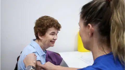 Getty Images Pamela Rawson speaks with nurses Emma McCallum ahead of receiving the COVID-19 AstraZeneca vaccine