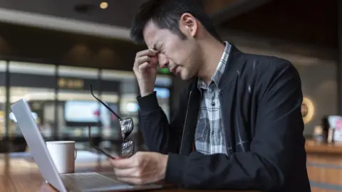 Getty Images Stressed man working with laptop