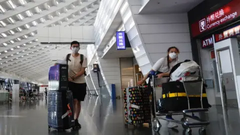 Getty Images Arriving overseas students wait for a taxi connecting to quarantine hotels, at Taoyuan International Airport, amid COVID-19 pandemic, in Taoyuan, Taiwan, 26 September 2021.