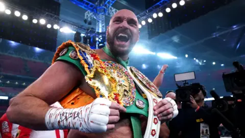 PA Media Boxer Tyson Fury seen holding his belts after beating fellow British heavyweight Dillian Whyte