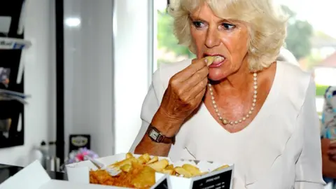 Getty Images Camilla, Duchess of Cornwall, samples haddock and chips while visiting Bridlington in 2013