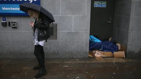 Getty Images Homeless man sleeping in Manchester doorway