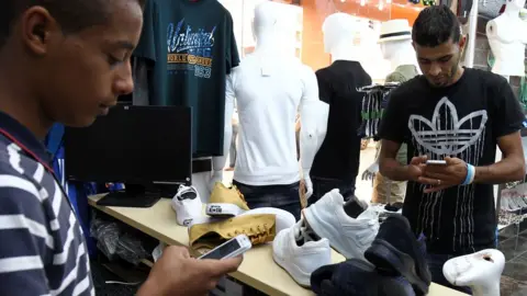 Getty Images Two men use their phones to pay