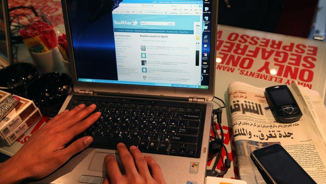 A man looks at a laptop computer displaying Twitter in a cafe in Cairo, Egypt.