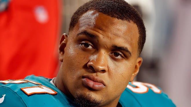 Center Mike Pouncey of the Miami Dolphins watches his team from the bench.