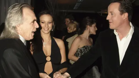 Getty Images Peter Stringfellow, Bella Wright and David Cameron attend the Conservative Party Black & White Ball