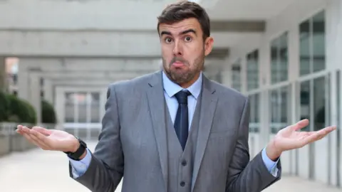 Getty Images businessman shrugging his shoulders
