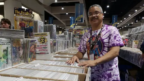 Reuben Miranda surrounded by comic books