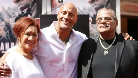 Getty Images Rocky Johnson (R) with his son Dwayne "The Rock" Johnson (C) and ex-wife Ata Johnson (L)