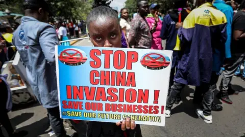 EPA Kenyan small and medium enterprise traders hold placards and shout slogans during a protest against Chinese nationals owning businesses that engage in import, manufacture and distribution