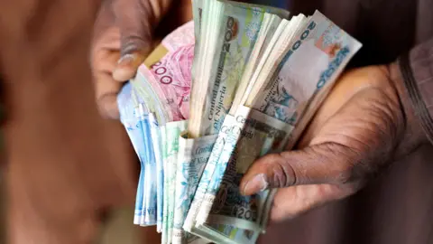 Reuters A man counting money in Nigeria