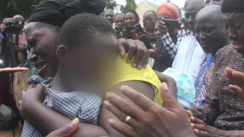 AFP A mother hugs her daughter after she was released by kidnappers in Kaduna - 2021