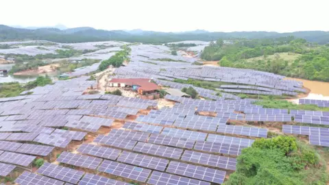 Wang Xiqing/BBC Rows of solar panels surrounding a house