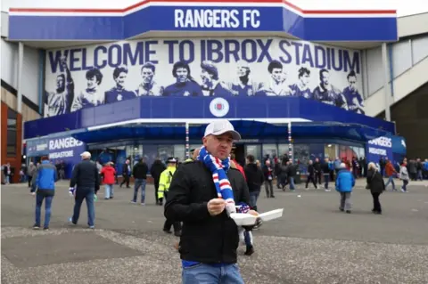 Getty Images A Rangers fan arrives at the stadium prior to kickoff during the Ladbrokes Scottish Premiership match between Rangers and Celtic at Ibrox Stadium on April 29, 2017