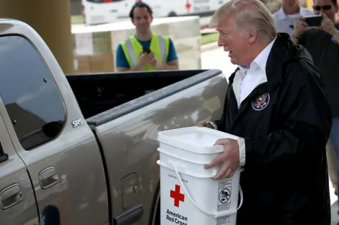 Getty Images President Trump carries emergency supplies to a waiting pickup truck for residents hit by Hurricane Harvey while visiting the First Church of Pearland September 2, 2017 in Pearland, Texas