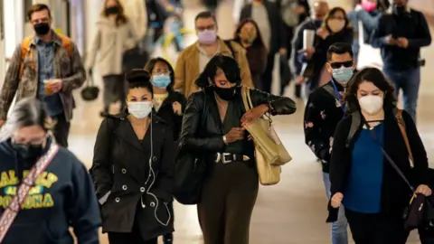 Getty Images Commuters wearing facemasks in Los Angeles in November